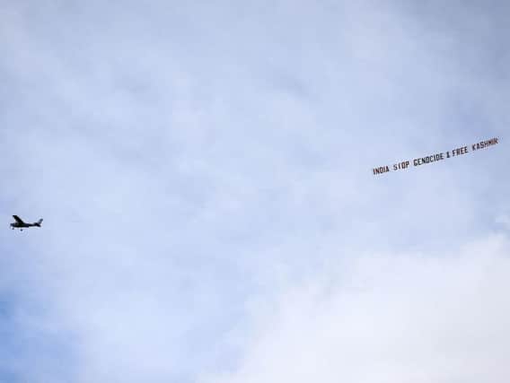 A plane flies over with a banner reading ' India stop Genocide & free Kasshmir' during the ICC Cricket World Cup group stage match at Headingley, Leeds. Picture: PA
