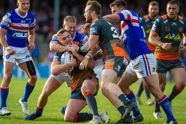 James Clare is tackled by the Wakefield Trinity defence - but the Castleford Tigers winger escaped long enough later to scorer a hat-trick of tries. (PHOTO: JAMES HEATON)