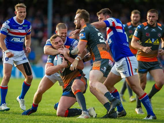 James Clare is tackled by the Wakefield Trinity defence - but the Castleford Tigers winger escaped long enough later to scorer a hat-trick of tries. (PHOTO: JAMES HEATON)