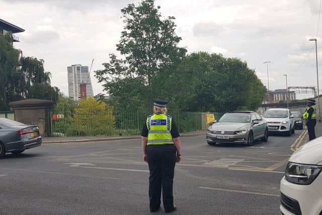 Three police officers divert traffic turning out from Globe Lane.