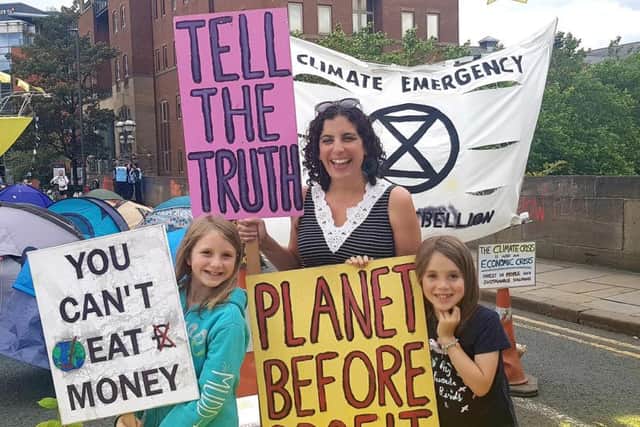 Thea Pilikian-Strachan (centre) protesting with two of her children, Marnie (left) and Blake (right).