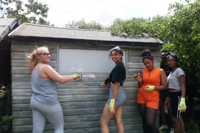 Young volunteers help paint a shed at Killingbeck Allotment Association.