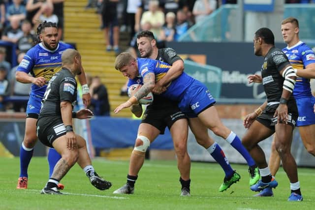 Liam Sutcliffe is tackled by Hull's Jake Connor.  Picture: Tony Johnson.