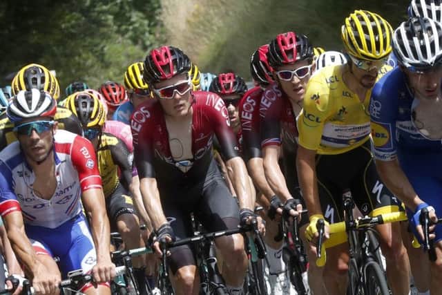 France's Julian Alaphilippe wearing the overall leader's yellow jersey rides in the pack with Britain's Geraint Thomas, center, right, and France's Thibaut Pinot, left, on Sunday. Picture: AP/Thibault Camus