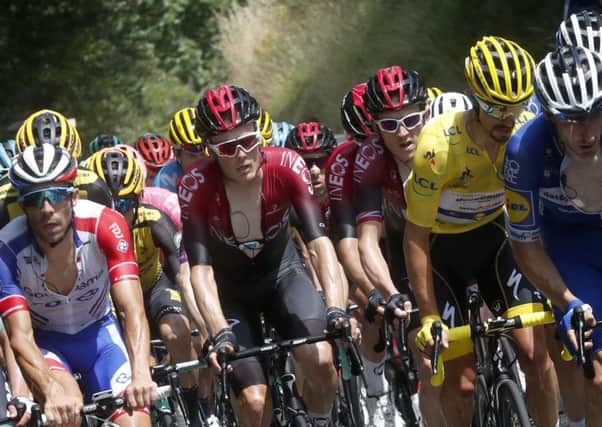 France's Julian Alaphilippe wearing the overall leader's yellow jersey rides in the pack with Britain's Geraint Thomas, center, right, and France's Thibaut Pinot, left, on Sunday. Picture: AP/Thibault Camus