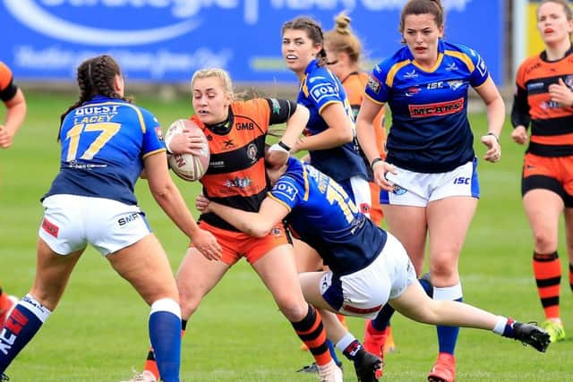 Castleford's Sinead Peach is tackled by Leeds' Shannon Lacey and Sophie Nuttall.