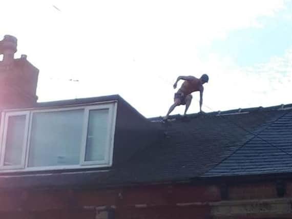 Officers have been called to Harehills where they tried to coax a man with no shirt on down from a roof. Picture: Scott Bell