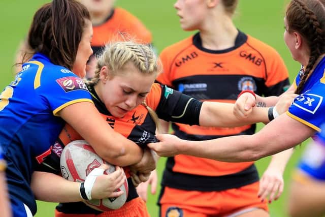 Castleford's Sinead Peach  tackled by Leeds' Ellie Oldroyd and Dannielle Anderson.