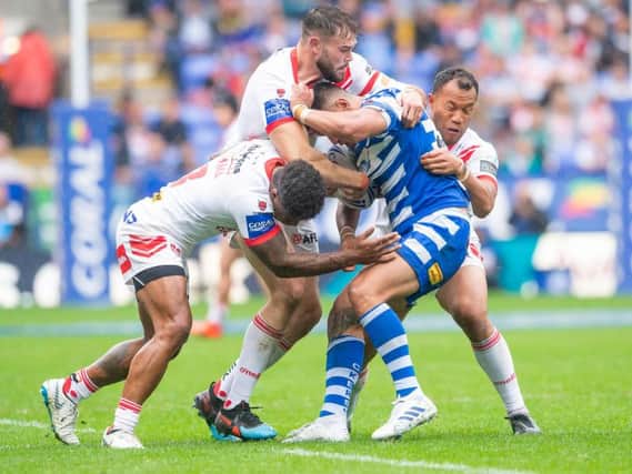 Halifax's Adam Tangata is held by St Helens' defence. Picture by Allan McKenzie/SWpix.com