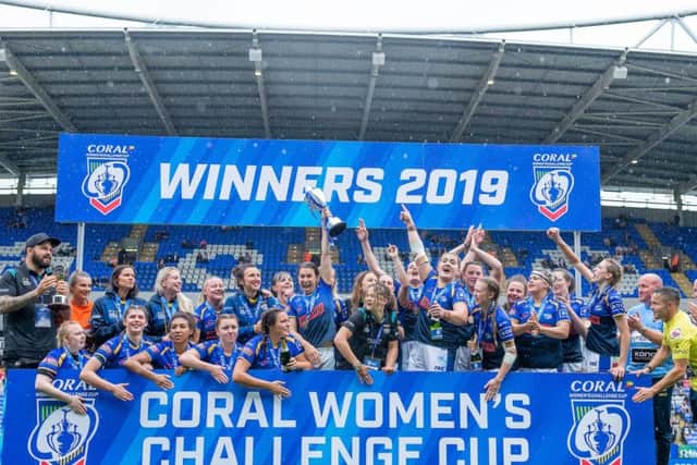 Leeds Rhinos' Courtney Hill, centre, lifts the Challenge Cup trophy after her side's 16-10 victory over Castleford Tigers.