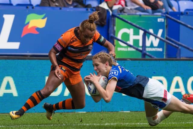 Caitlin Beevers touches down to score for Leeds Rhinos despite the best efforts of Kelsey Gentles.