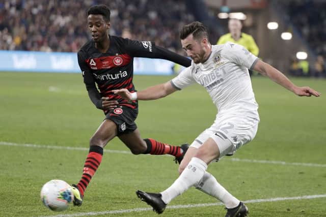 Leeds United's Jack Harrison, right, kicks past Western Sydney Wanderers' Bruce Kamau during their friendly soccer match in Sydney, Australia, Saturday, July 20, 2019. (AP Photo/Rick Rycroft)