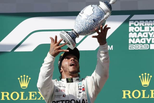 Mercedes' Lewis Hamilton celebrates on the podium after winning the Hungarian Formula One Grand Prix. Picture: AP/Laszlo Balogh