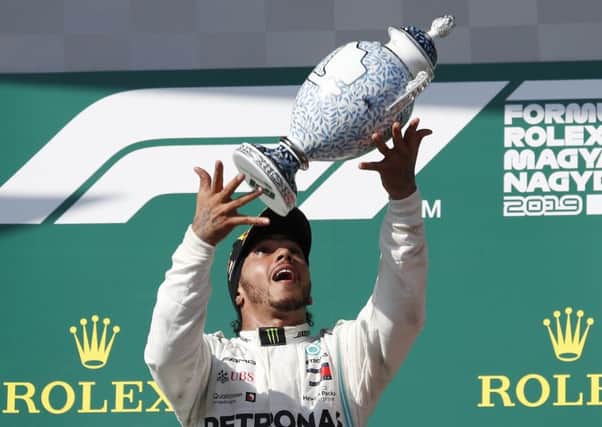 Mercedes' Lewis Hamilton celebrates on the podium after winning the Hungarian Formula One Grand Prix. Picture: AP/Laszlo Balogh