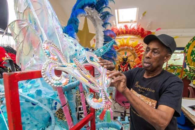 Arthur France, MBE, Chairman of The Leeds West Indian Carnival, checks over the carnival costumes.
