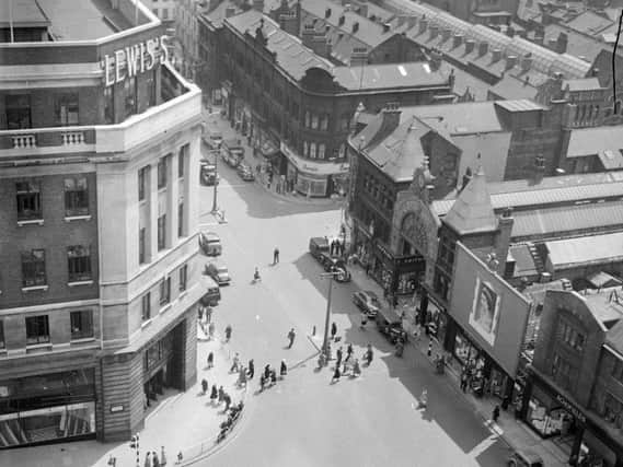 Rooftop view of the Headrow in Leeds City Centre. Lewis's shop in the foreground, left and Schofields on the right.. Possibly from 1953, as there is a prominent picture of Queen Elizabeth II in front of Schofield's department store.