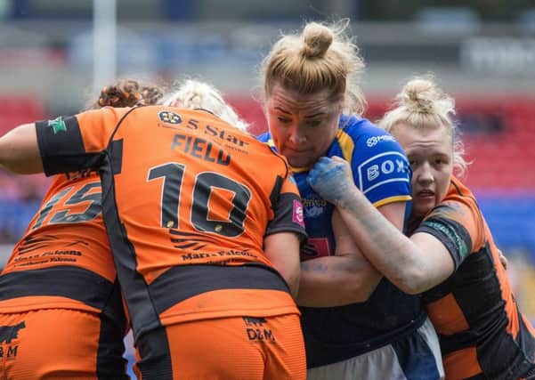 Danika Prim of Leeds is tackled by Grace Field and Georgia Roche of Castleford.