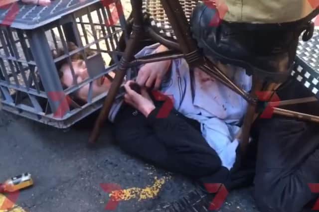 Screengrab taken with permission from a video issued by 7 News of a man being tackled with a milk crate and chairs by members of the public in Sydney, Australia, following a knife attack.  (Photo: Andrew Denney/7 News/PA Wire)