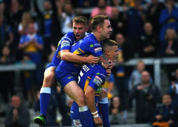 Rhinos' Ash Handley is congratulated on his try by Richie Myler and Jack Walker.