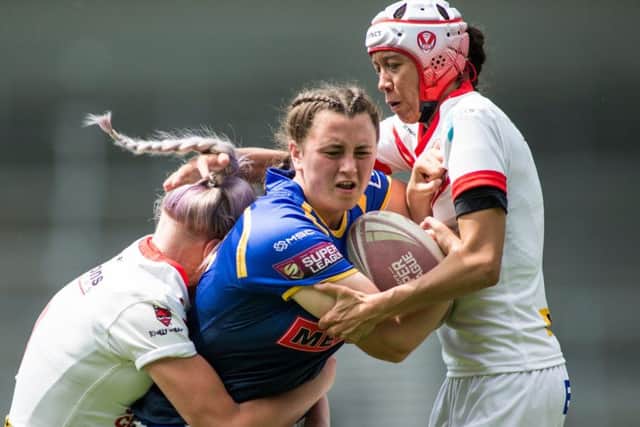 Shannon Lacey of Leeds is tackled by Naomi Williams and Zoe Harris of St Helens.
