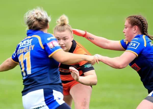 Castleford's Georgia Roche tackled by Leeds' Aimee Staveley and Dannielle Anderson.