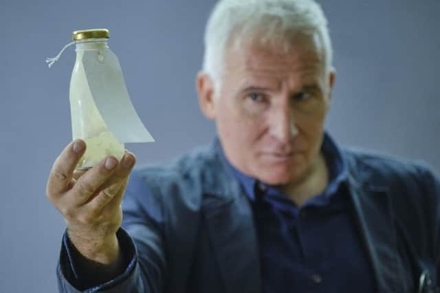 Simon Hedges with one of the bottles used in the installation at Scarborough Art Gallery