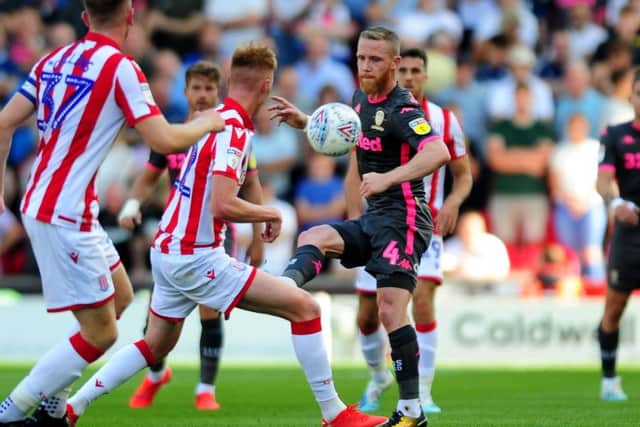 Adam Forshaw is challenged by the Stoke defence.