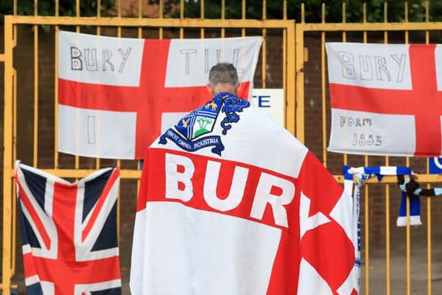 A Bury fan at the gates of Gigg Lane.