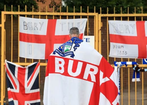 A Bury fan at the gates of Gigg Lane.