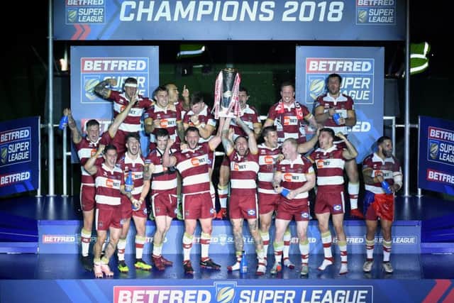 Wigan captain Sean O'Loughlin and Sam Tomkins lift the Betfred Super League trophy.