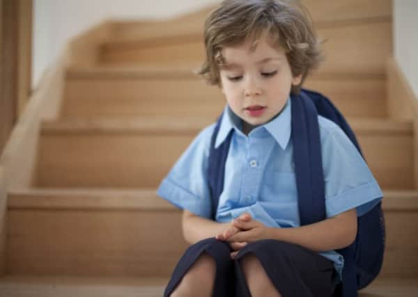 First day of school young boys sits nervous on the stairs of Australian house