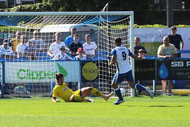 Aaron Martin scores for Guiseley past Alfreton Town goalkeeper Jack Atkinson. Picture: Steve Riding.