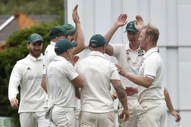 Otley players celebrate a wicket by Dermot Reeve, right, who took four wickets in the win over visitors Pool to keep them clear at the top of Division 1. PIC: Steve Riding
