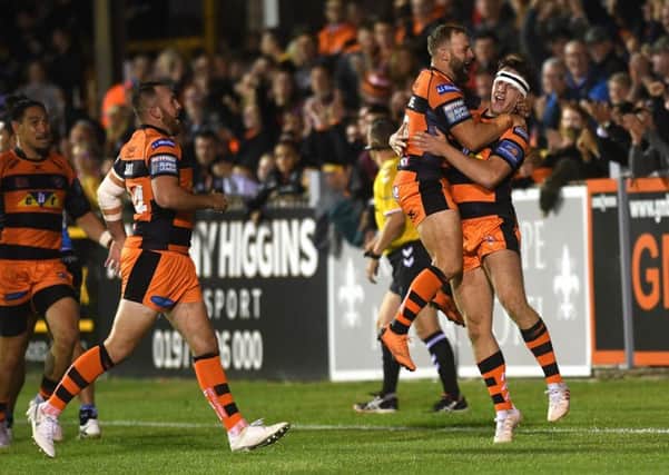 Tigers' Jake Trueman is congratulated on his hat-trick try by Paul McShane.