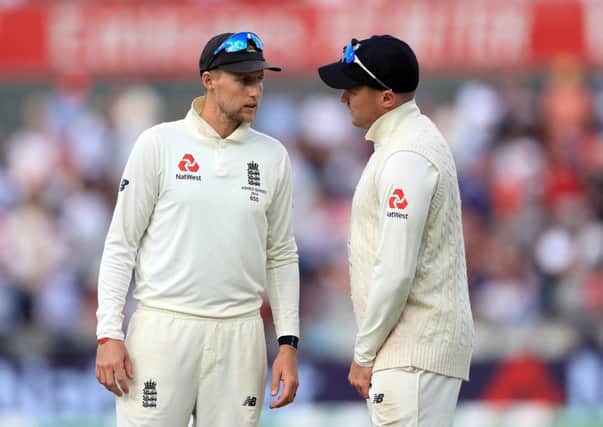 England's Joe Root (left) and Jason Roy discuss tactics on day four at Old Trafford. Picture: Mike Egerton/PA.