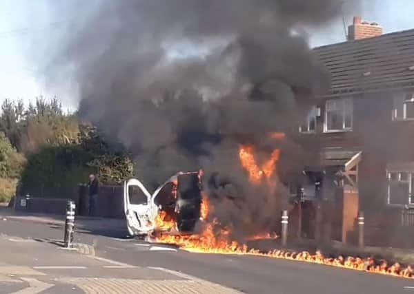A police van on fire outside homes on Ullswater Crescent in Halton Moor