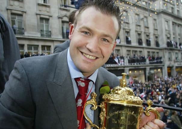 On top of the world: England's Mark Regan holds the Webb Ellis Cup during the victory parade in 2003.