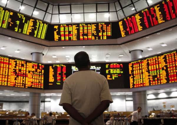 Watching the market: Warning signs from China, Europe and the US lead some to believe a downturn is overdue. PHOTO: AP Photo/Vincent Thian