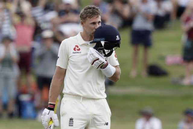England's Joe Root kisses his helmet as he celebrates his century against New Zealand at Seddon Park. Picture: AP/Mark Baker