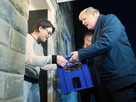Boris Johnson delivers milk to Debbie Monaghan in Guiseley. Photo: PA