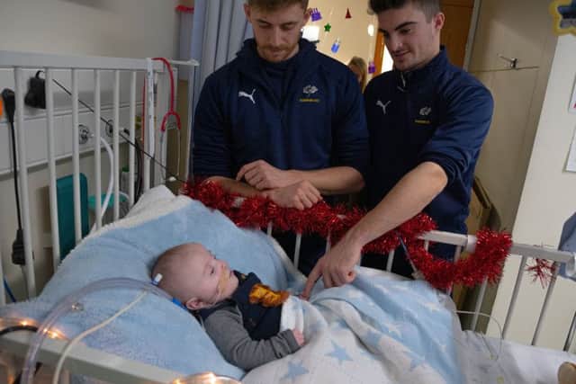 Festive spirit: Yorkshire players Ben Coad and Jordan Thompson during a visit to deliver gifts to youngsters at Leeds General Infirmary on Thursday. Pictures: Ben Wickett