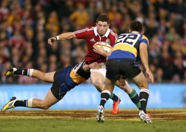 British & Irish Lions' Alex Cuthbert (centre) breaks through the tackle of NSW-Queensland Country's Alex Gibbon (left).