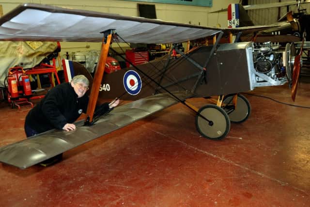 Volunteer Marie Taylor painting the strings on the wings of the reproduction 1917 Eastchurch Port Victoria Kitten fighter aircraft