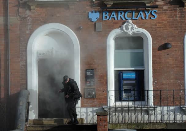 A police officer enters the 'smoke'-filled bank