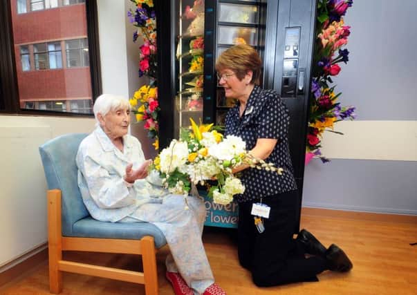 Catherine Vowles receives silk flowers from Norah Charlesworth at St James's Hospital