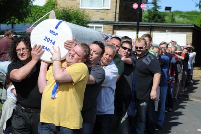 Residents carry the maypole into position in Barwick-In-Elmet. Picture: James Hardisty (JH100378a).