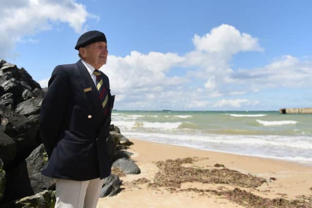 Normandy veteran Harry Mason, 95, from Warrington, looks out from the beach at Arromanches and the remains of Mulberry Harbour where he landed with British forces on 7 June 1944.