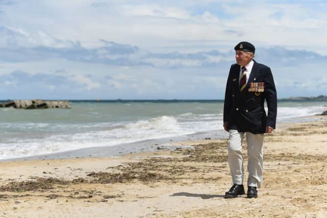 Normandy veteran Harry Mason, 95, from Warrington, looks out from the beach at Arromanches and the remains of Mulberry Harbour