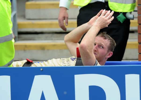 Aidy White cheers the travelling Leeds fans as he is stretchered off the pitch.  Picture by Bruce Rollinson