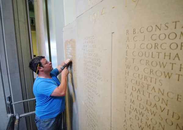 Stonemason Dave Phillips adds the names.